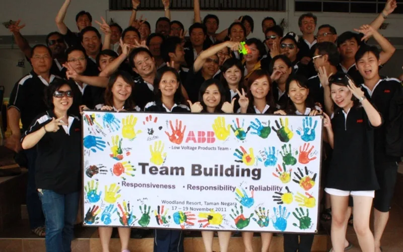 ABB staff behind a team building banner