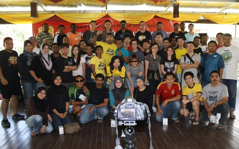 A large DiGi group photo under a resort welcome banner at Bukit Merah
