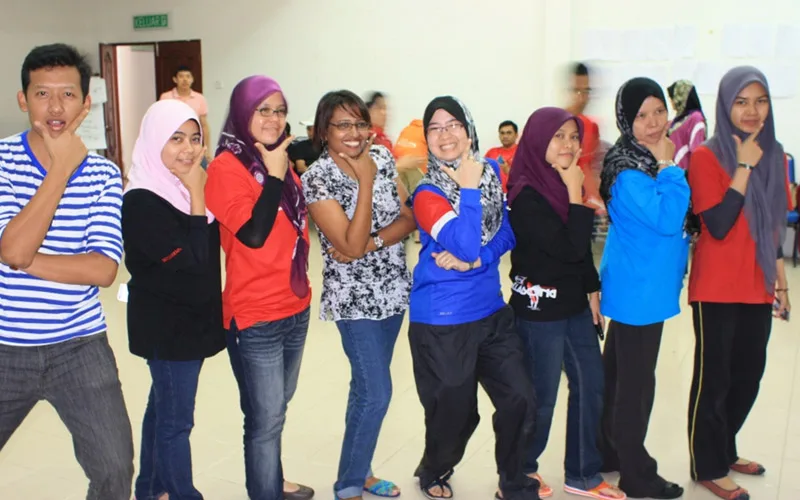 A line of Honda participants striking the same pose during an indoor activity