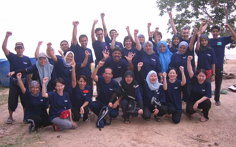 A large Maybank group photo at a QOM beach team programme