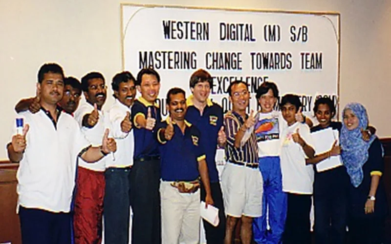 A workshop group behind their mastering change banner