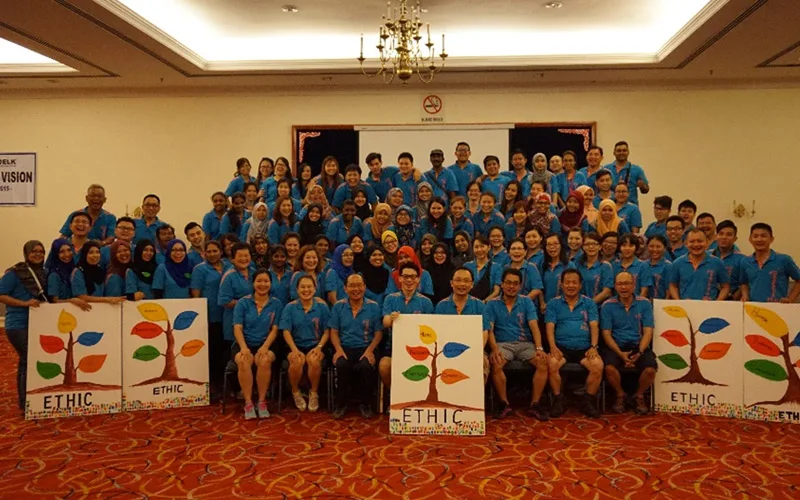 A large corporate group in matching shirts in a ballroom
