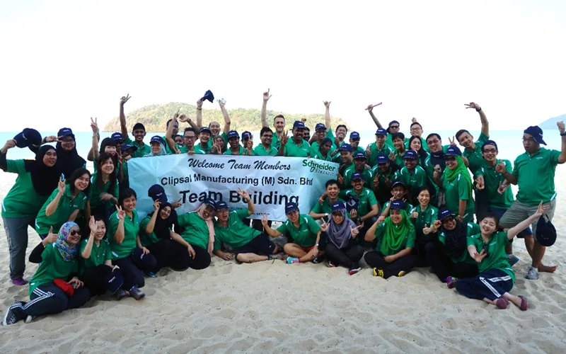A large group photo at a beach team building programme