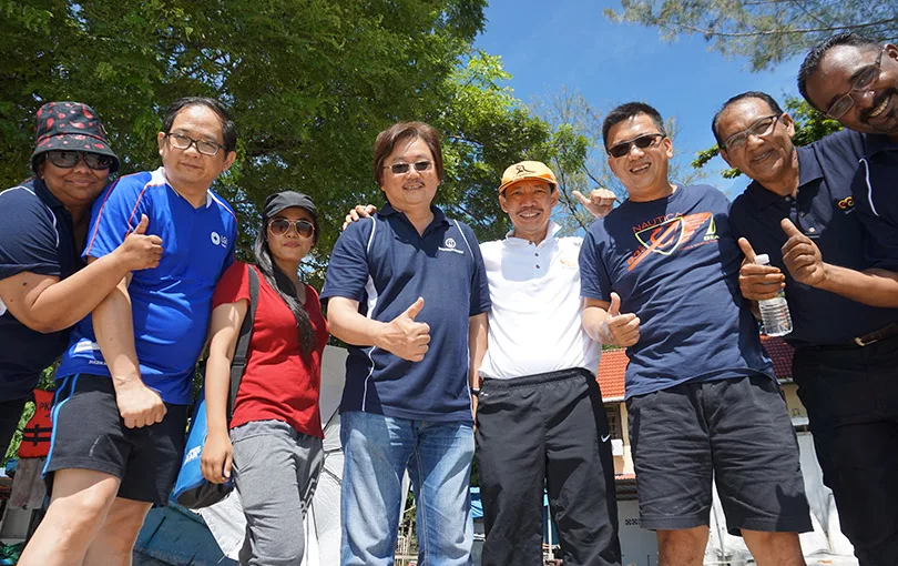 A team giving thumbs up outdoors in the sun