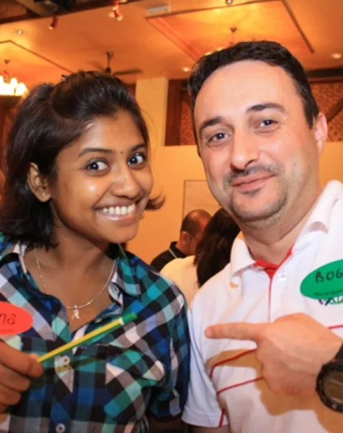 Two participants wearing name tags smiling at an indoor session