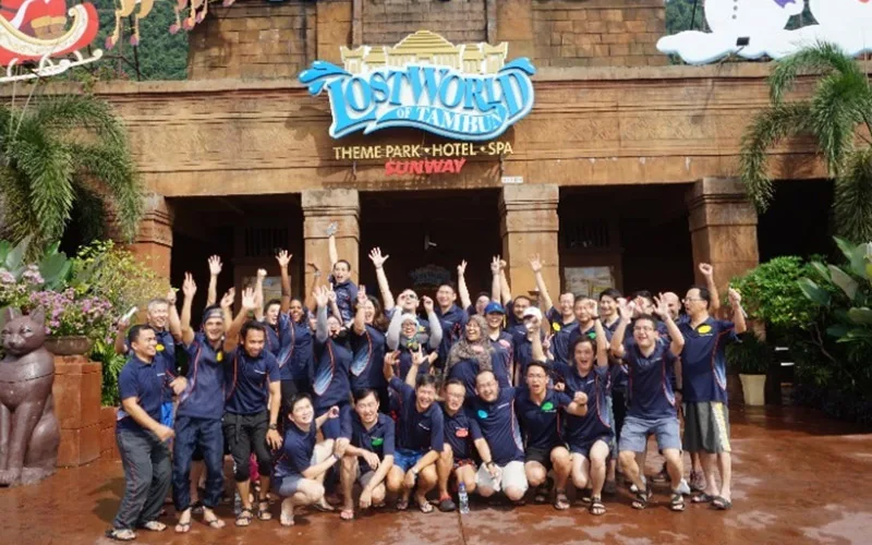 A large team in matching shirts at a theme park entrance